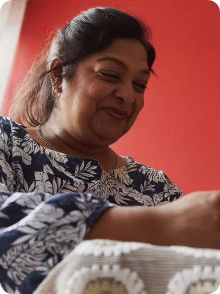 woman looking down smiling at phone using whatsapp status